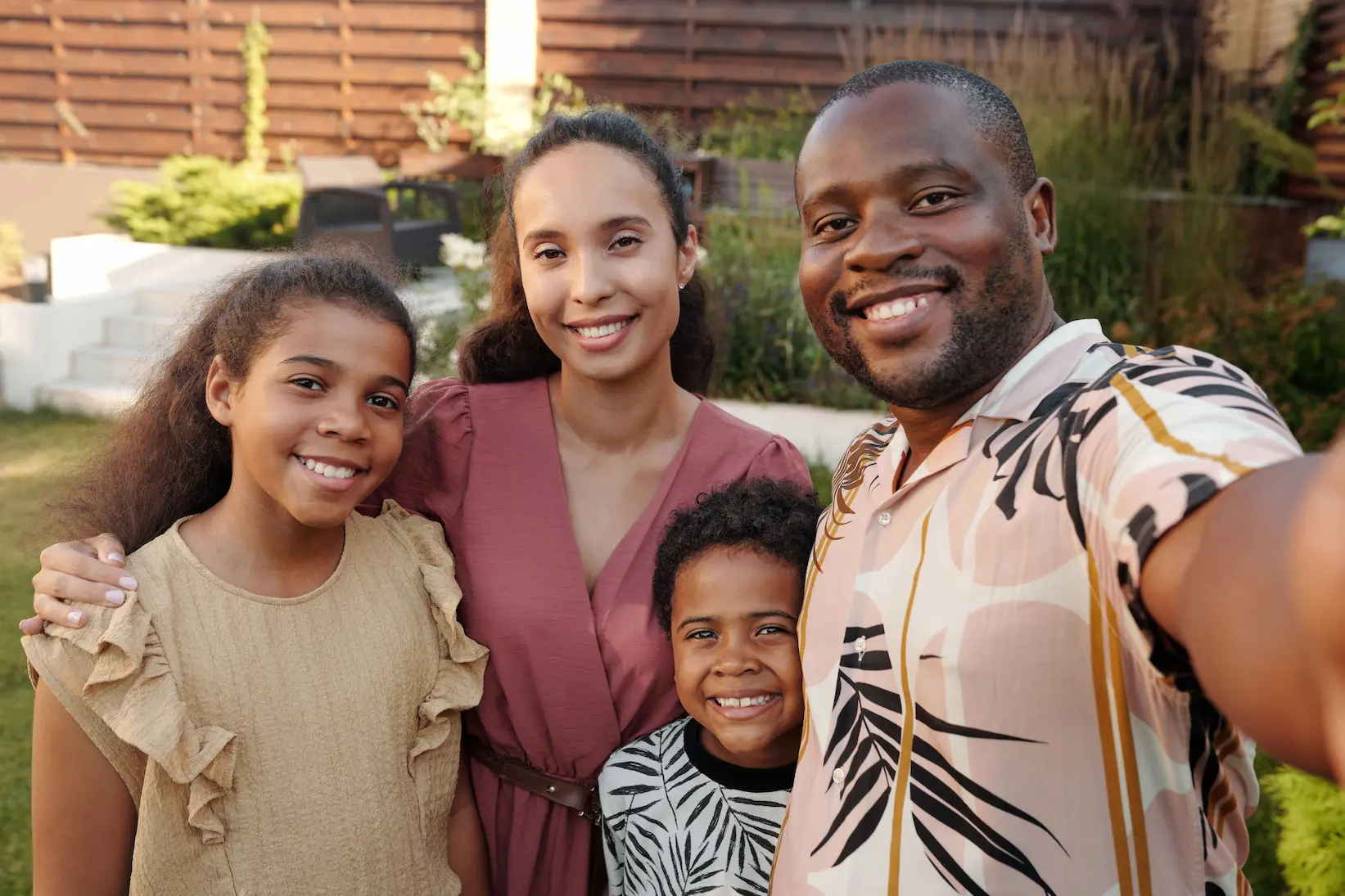 A smiling family of four outdoors